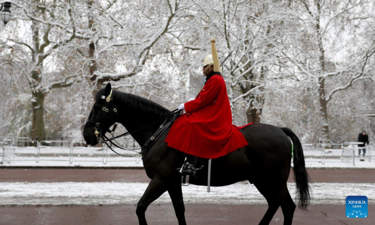 A member of the Household Division leaves Buckingham Palace in London, Britain, Dec 12, 2022. Snow blanketed London on Monday. Photo:Xinhua