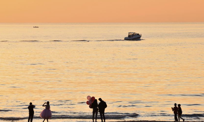 People enjoy the sunset on the beach of the Mediterranean Sea in Beirut, Lebanon, on Nov. 20, 2022. (Xinhua/Liu Zongya)