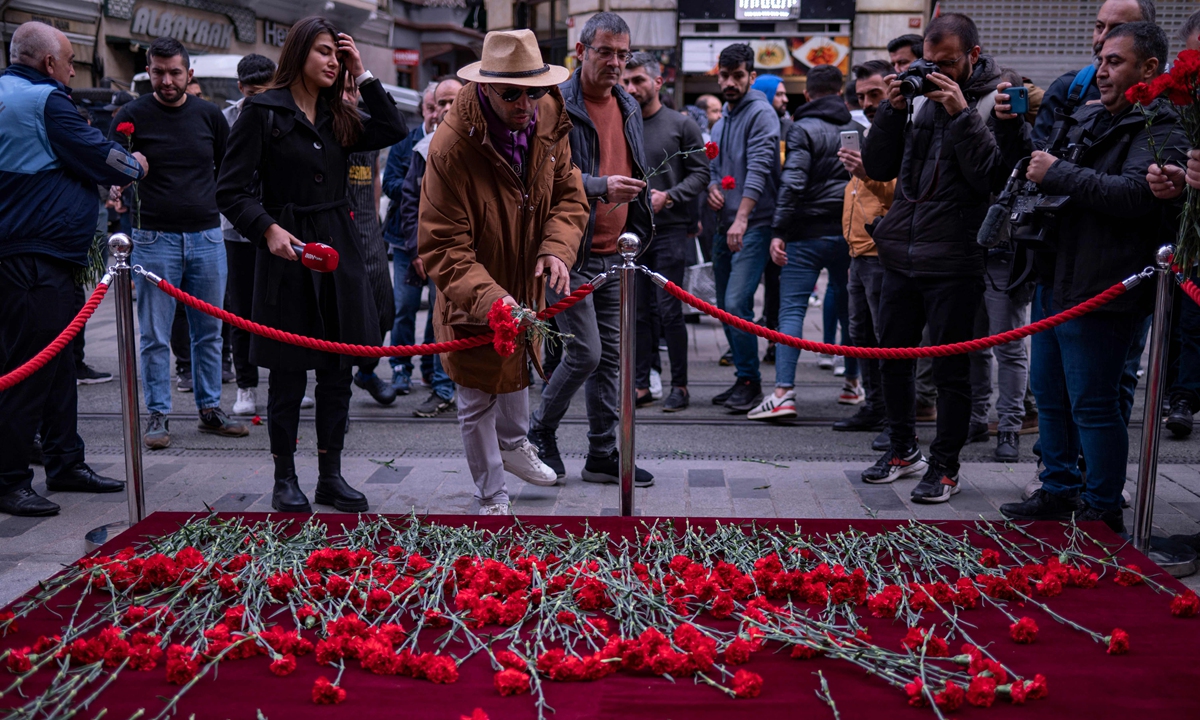 A mourner lays flowers as people grieve the victims of a November 13 explosion, which left six dead and 81 wounded, at the busy shopping street of Istiklal in Istanbul, Turkey, on November 14, 2022. The Istanbul Police Department said the suspect was a Syrian national and that she received the attack order from the outlawed Kurdistan Workers' Party and its offspring in Syria, the People's Protection Units. Photo: AFP