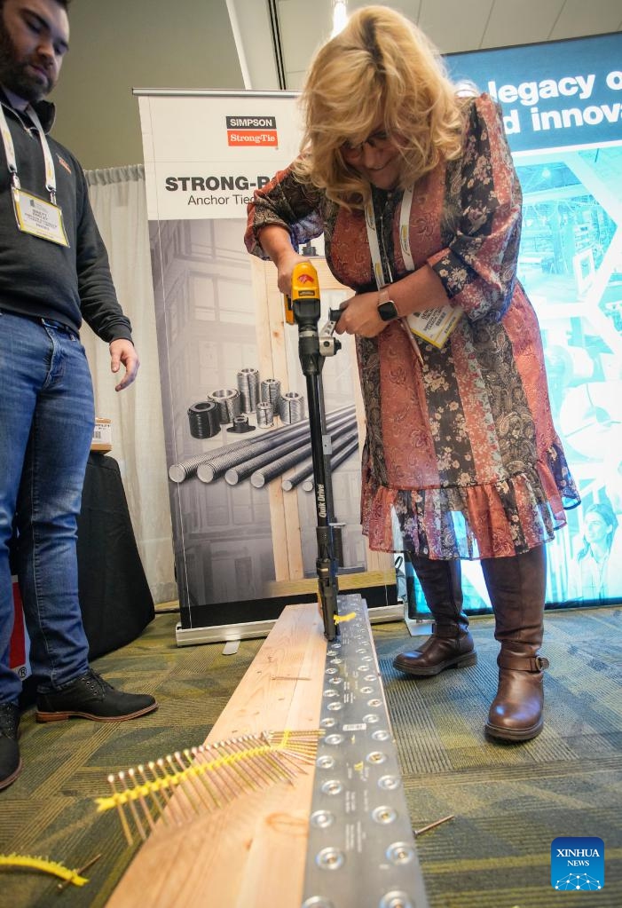 An event attendee tries a motorized screwdriver at an exhibition hall during the Wood Solutions Conference in Vancouver, British Columbia, Canada, on Nov. 15, 2022.Photo: Xinhua
