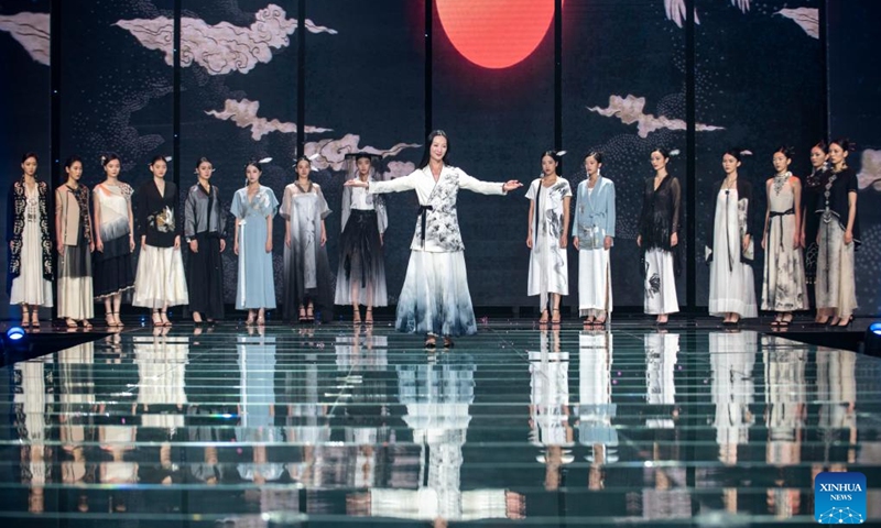 A designer (C) displays her creations during the opening ceremony of an ethnic clothing festival held in Kunming, southwest China's Yunnan Province, Nov. 15, 2022. Creations from different ethnic groups of Yunnan will be presented during the ethnic clothing festival. (Xinhua/Chen Xinbo)
