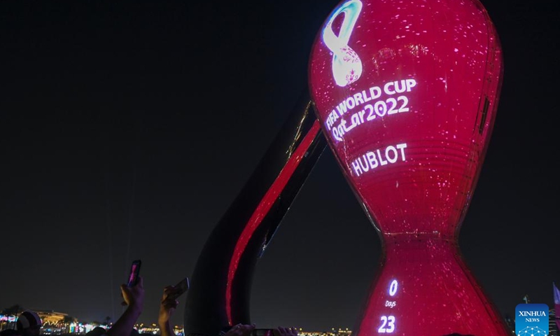 People take photos of the FIFA World Cup 2022 countdown clock in Doha, Qatar, on Nov. 19, 2022, on the eve of Qatar 2022 World Cup. (Photo by Nikku/Xinhua)