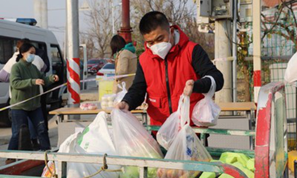 A volunteer delivers living supplies to residents in Beijing's Daxing district on November 20, 2022. Photo: from IC.