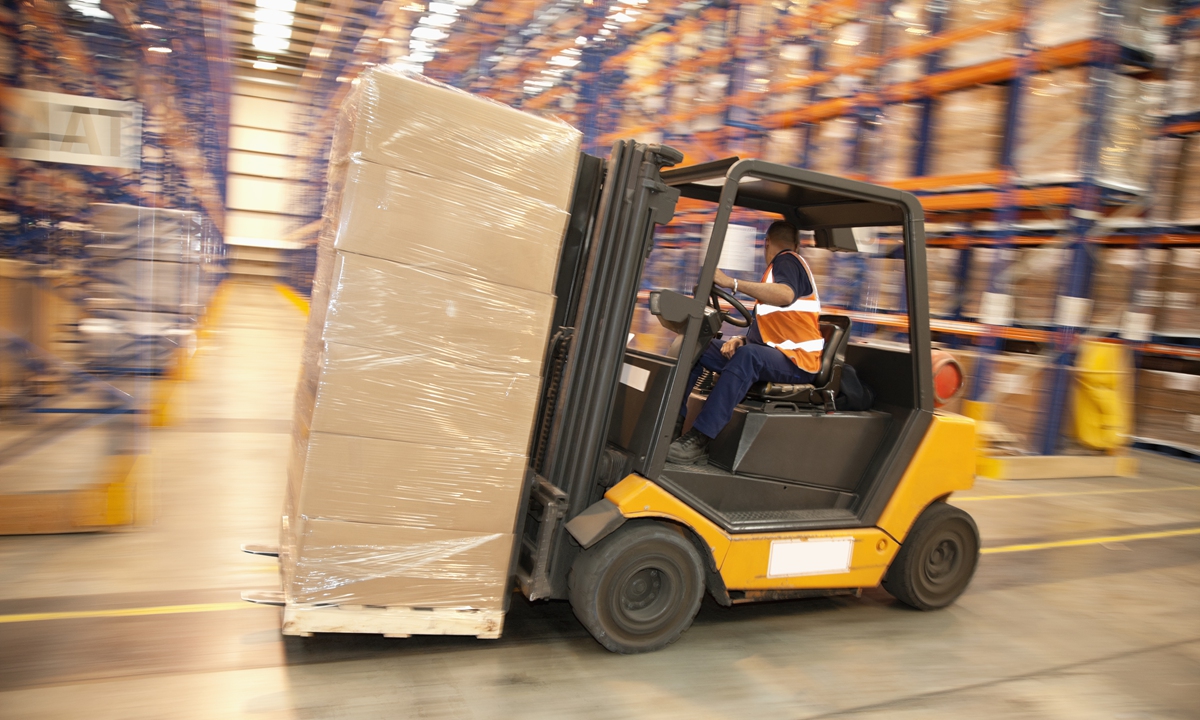 A worker drives forklift at warehouse. Photo: VCG