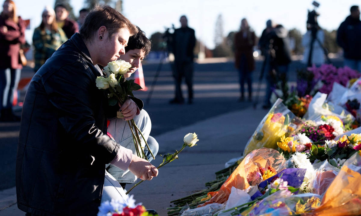en Kurgis (L) and Jessie Pacheco (R) pay their respects to the victims of the mass shooting at Club Q, an LGBTQ nightclub, in Colorado Springs, Colorado, on November 20, 2022. At least five people were killed and 18 wounded in a mass shooting at an LGBTQ nightclub in the US city of Colorado Springs, police said on November 20, 2022. Photo: VCG