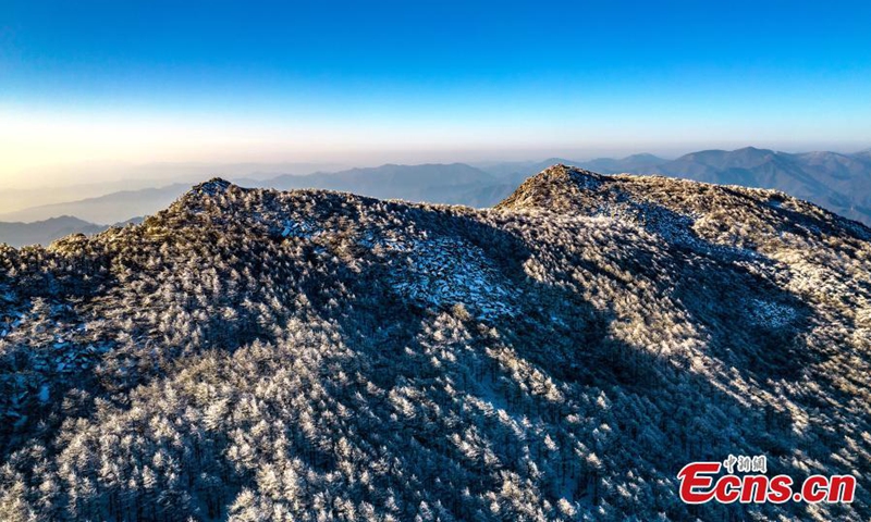 2022 年 11 月 22 日，冬天的日出照耀在中国西北部陕西省西安市朱雀国家森林公园的山峰上，把它变成了一个白色的仙境。  （摄影：中新社/程文英）
