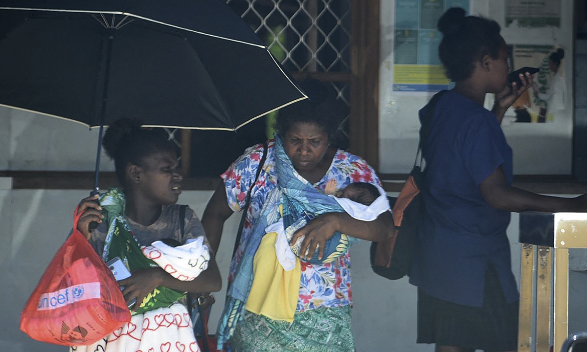 A family leaves a hospital building in downtown Honiara on November 22, 2022. People rushed from their offices and fled to higher ground after a strong 7.0 magnitude earthquake struck the Solomon Islands. Photo: AFP