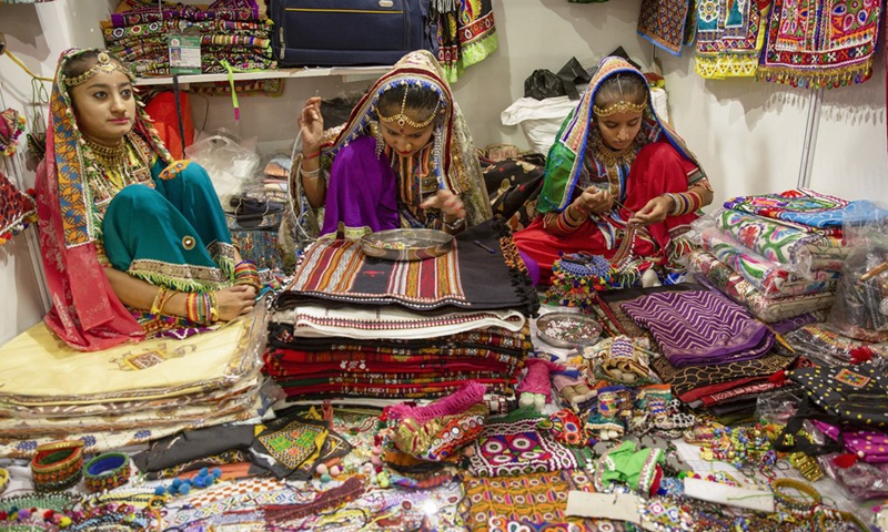 Girls sell handicrafts of Indian state Gujarat during India International Trade Fair 2022 in New Delhi, India, Nov. 22, 2022. (Xinhua/Javed Dar)