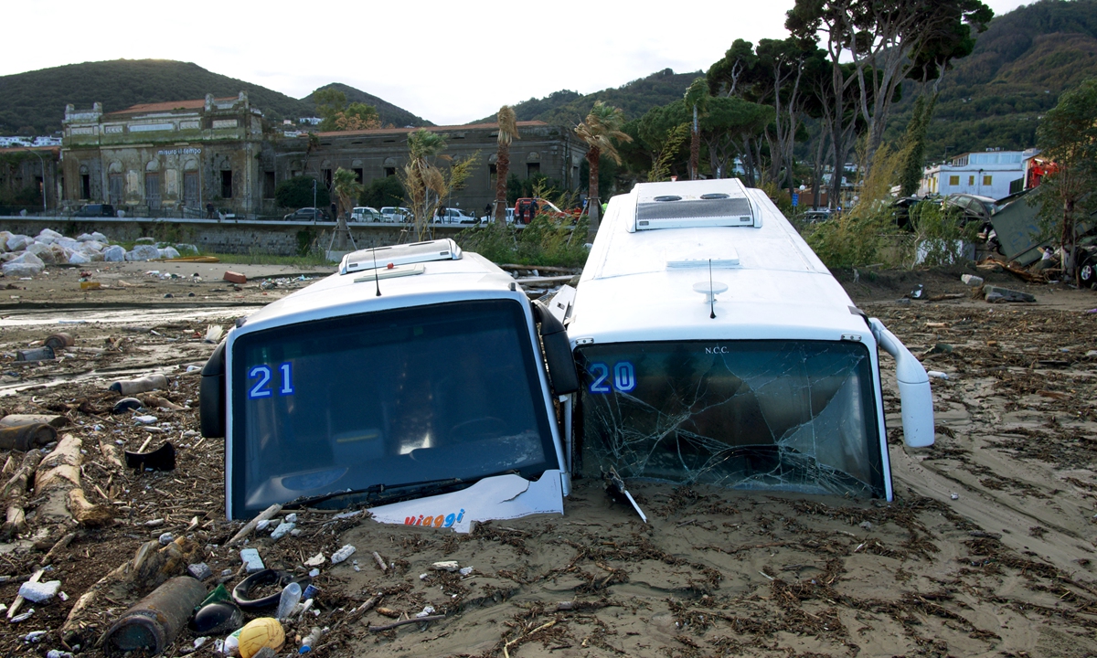Damaged tourist buses are seen on the port of Casamicciola on November 27, 2022, following heavy rains that caused a landslide on the island of Ischia, southern Italy. Italian rescuers were searching for a dozen missing people on the southern island of Ischia after a landslide killed at least one person, as the government scheduled an emergency meeting. Photo: AFP