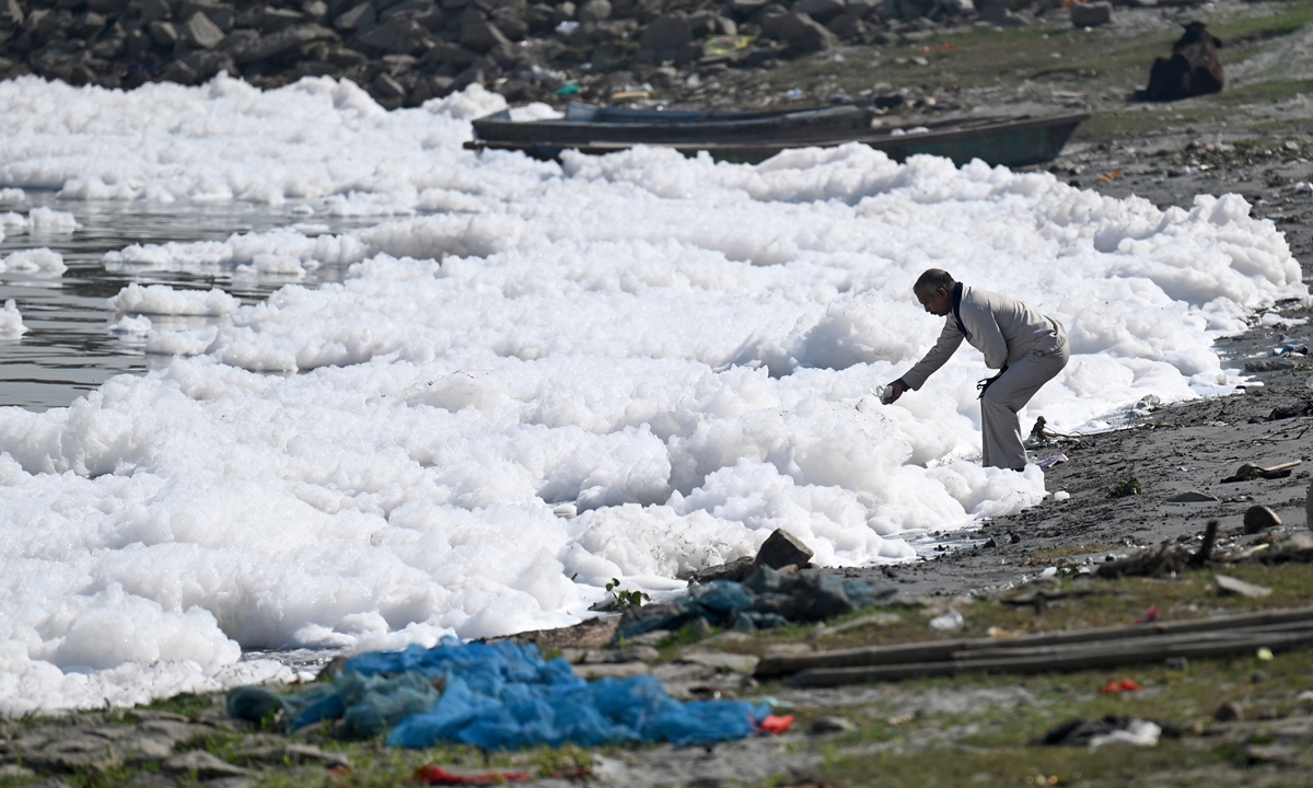 A man performs a religious ritual on the bank of the polluted Yamuna River, covered in swathes of bright white toxic foam, in New Delhi, India on November 24, 2022. The foam is partly the result of poor management of waste from the nearby industrial hubs and New Delhi's more than 20 million residents, said NBC News. Photo: AFP