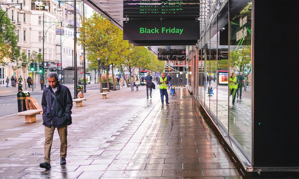 A man walks past a Black Friday sign outside a retail shop in Oxford Street in London, the UK on November 25, 2022. 
Photo: VCG