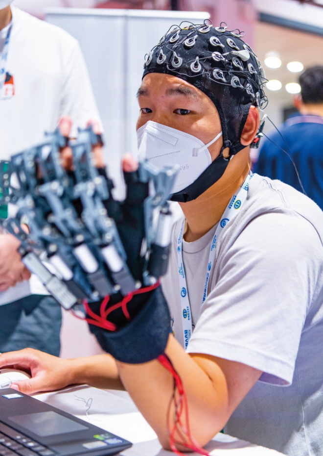 A researcher tests a BCI device at the 2022 World Robot Conference held in Beijing. Photo: VCG