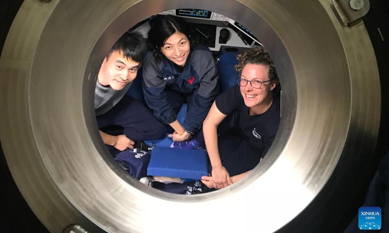 Submersible pilots Deng Yuqing (C) and Yuan Xin (L) from China's Institute of Deep-Sea Science and Engineering (IDSSE) of the Chinese Academy of Sciences, and New Zealand Marine biologist Dr. Kareen Schnabel from the National Institute of Water and Atmospheric Research, prepare for their expedition to the Kermadec Trench onboard China's research vessel Tansuoyihao, Nov. 4, 2022.(Photo: Xinhua)