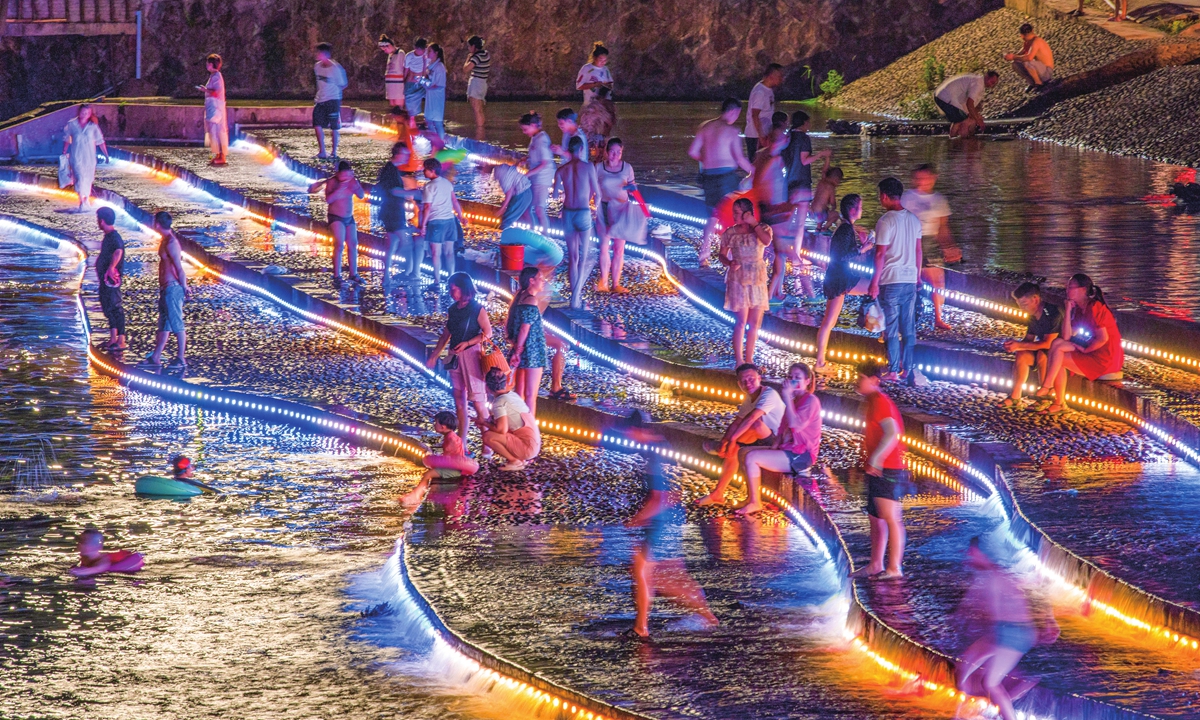 Tourists splash in the water in Bailongqiao township in Jinhua, East China's Zhejiang Province. The township has taken the lead in developing night economy to attract more tourists and stimulate local consumption. Photo: VCG