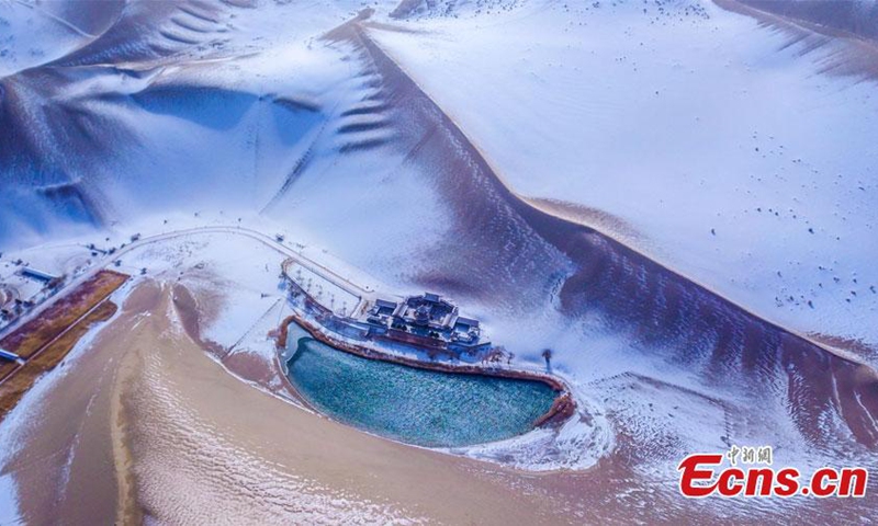 2022 年 11 月 27 日，中国西北部甘肃省敦煌市鸣沙山和月牙泉风景区的雪景。周日，敦煌迎来了今冬的第一场雪。  （摄影：中新社/王斌银）