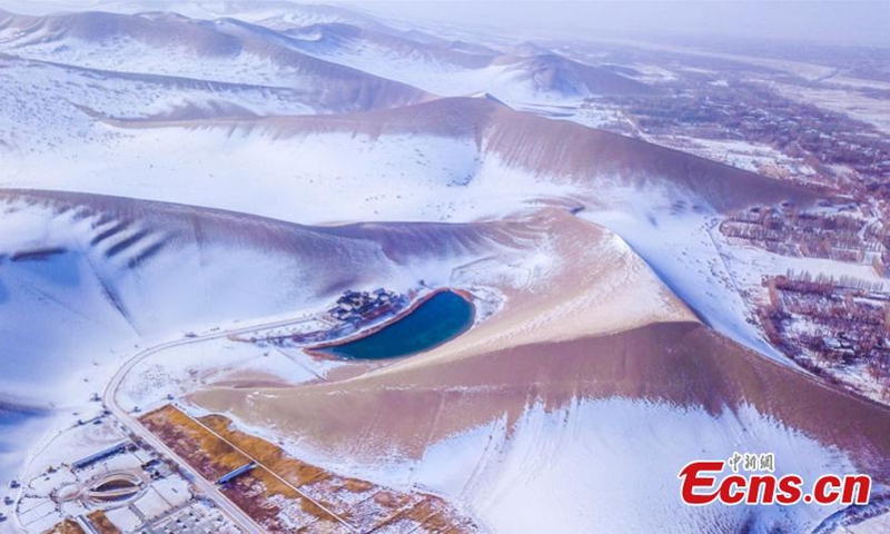 2022 年 11 月 27 日，中国西北部甘肃省敦煌市鸣沙山和月牙泉风景区的雪景。周日，敦煌迎来了今冬的第一场雪。  （摄影：中新社/王斌银）