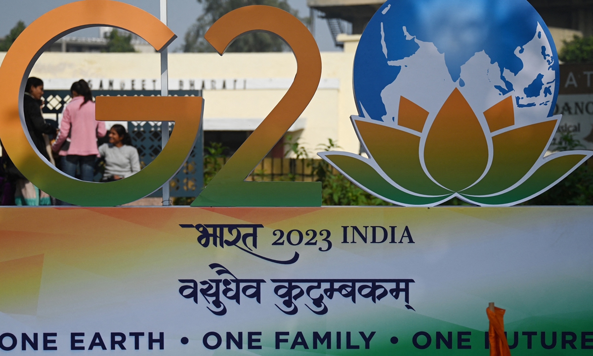Children stand next to the G20 logo after its unveiling in New Delhi, India on December 1, 2022, when India formally took over the Group of 20 presidency from Indonesia. During its presidency, it will hold about 200 meetings in 32 different sectors and on multiple locations across the country in 2023. Photo: AFP