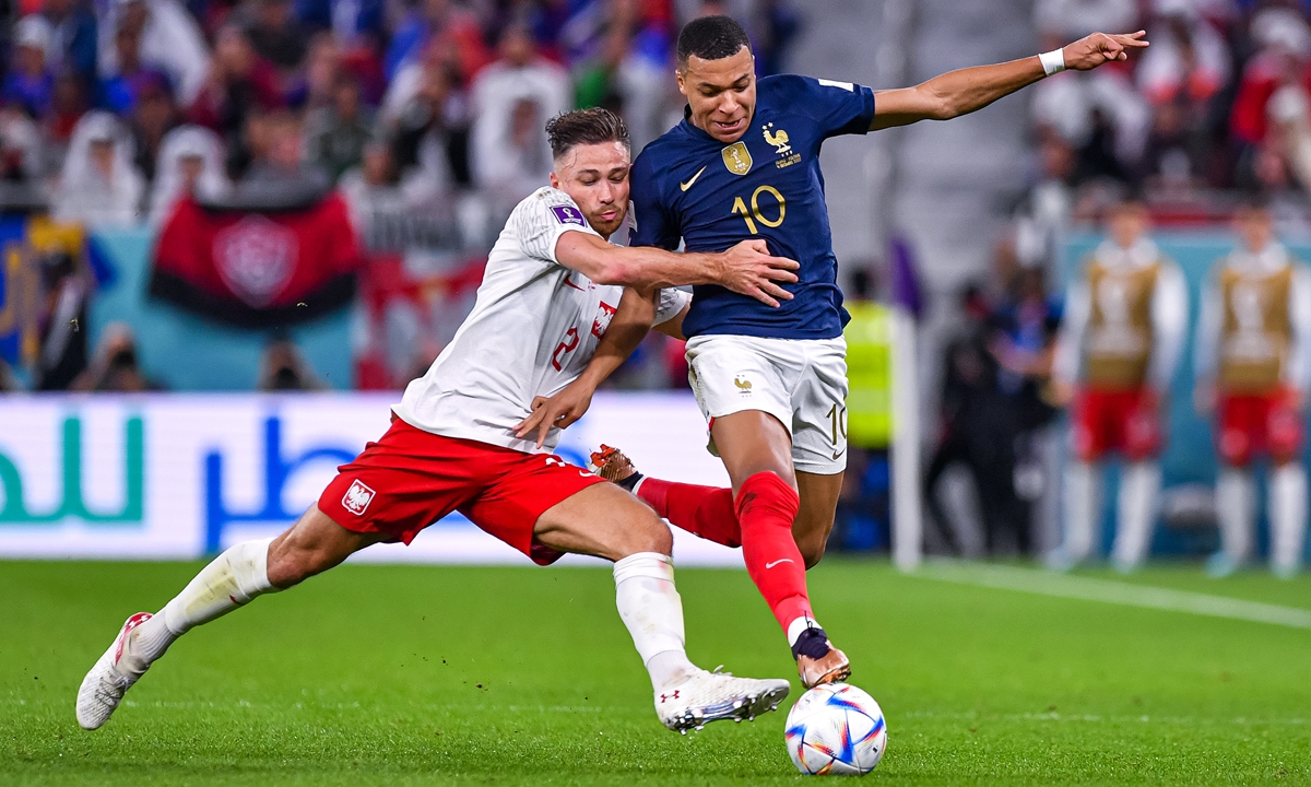 Kylian Mbappe (right) of France drives the ball under pressure from Matty Cash of Poland on December 4, 2022 in Doha, Qatar. Photo: VCG