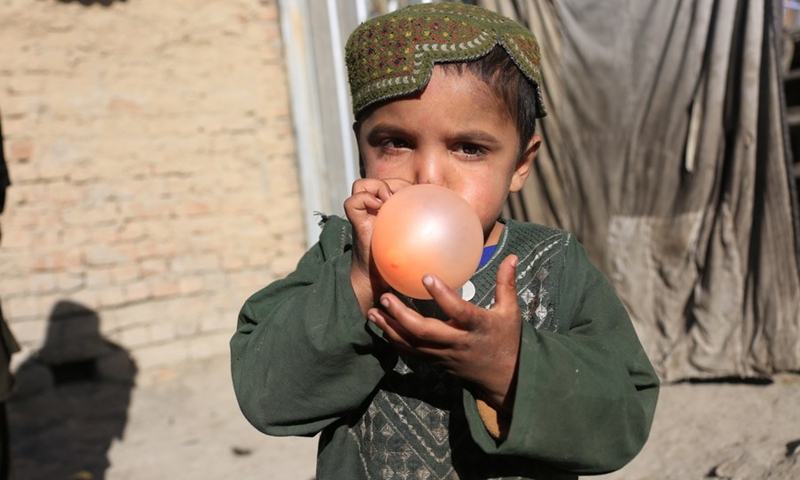 A child blows up a balloon at an internally displaced people's camp in Kabul, Afghanistan, Nov. 29, 2022.(Photo: Xinhua)