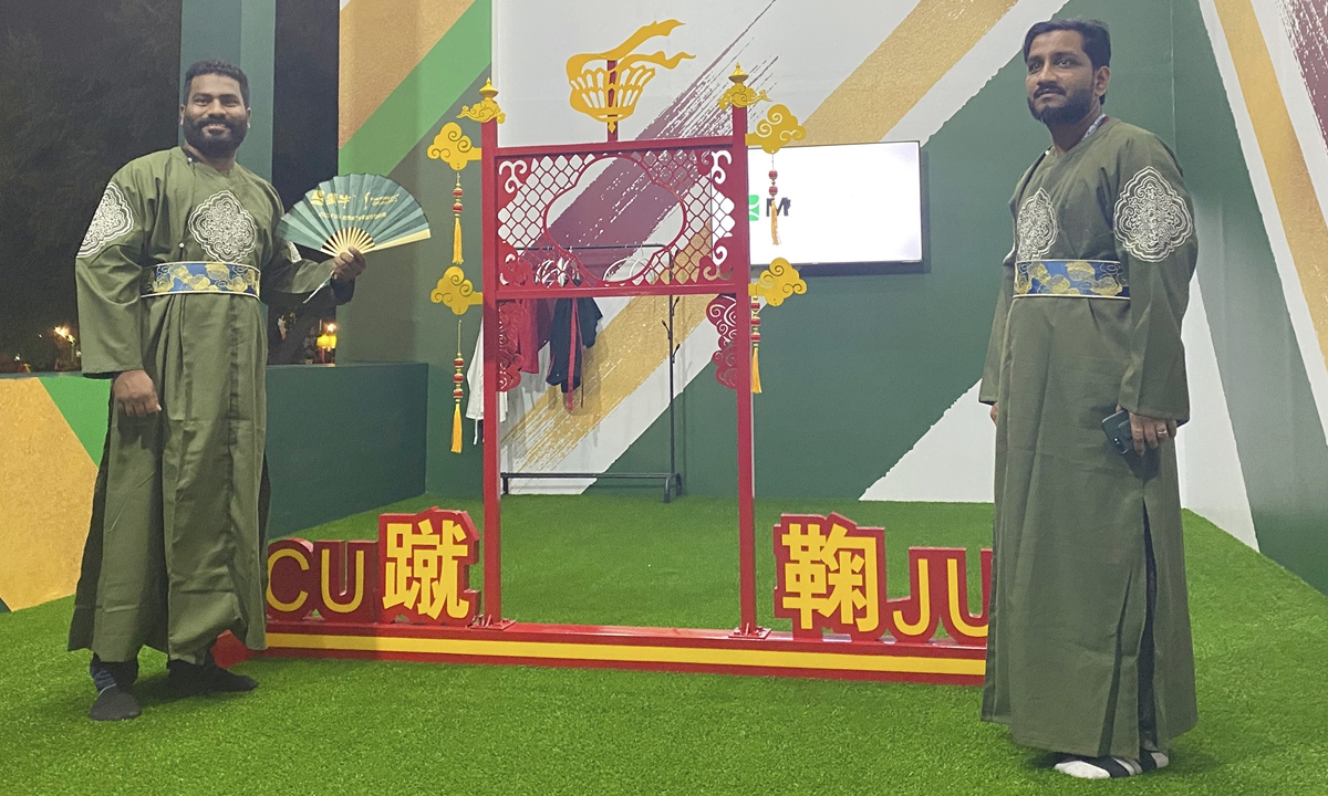 Two fans pose beside a goal used in the game of cuju in Doha, Qatar on November 21, 2022. Photo: Courtesy of the Network of International Culturalink Entities