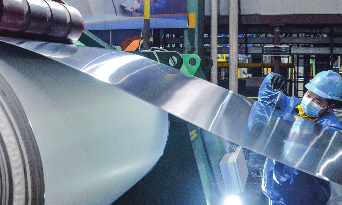 A worker measures the thickness of stainless steel coils in a factory in Wuxi, East China's Jiangsu Province on December 1, 2022. China's value-added industrial output went up 5 percent year-on-year in October, data from the National Bureau of Statistics showed. Photo: VCG