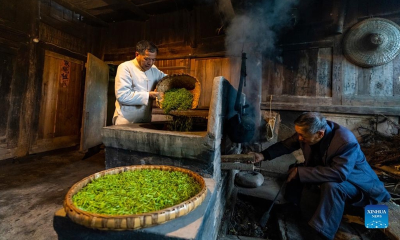 Zhang Yuehua (L) processes tea leaves in a traditional way at his ancestral house in Mingshan District of Ya'an City, southwest China's Sichuan Province, March 31, 2022. Zhang, born in 1959, is a representative inheritor of green tea making technique. Boasting a long history of tea cultivation, Ya'an is the birthplace of dark tea and green tea making techniques. Inherited by generations of tea makers, both techniques are now listed as national-level intangible cultural heritage.(Photo: Xinhua)