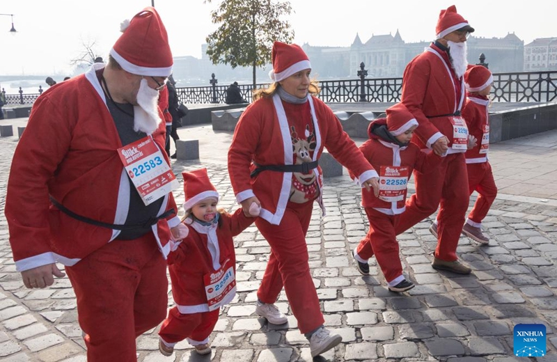 People in Santa Claus costumes participate in the Santa Run in downtown Budapest, Hungary on Dec. 4, 2022. (Photo by Attila Volgyi/Xinhua)