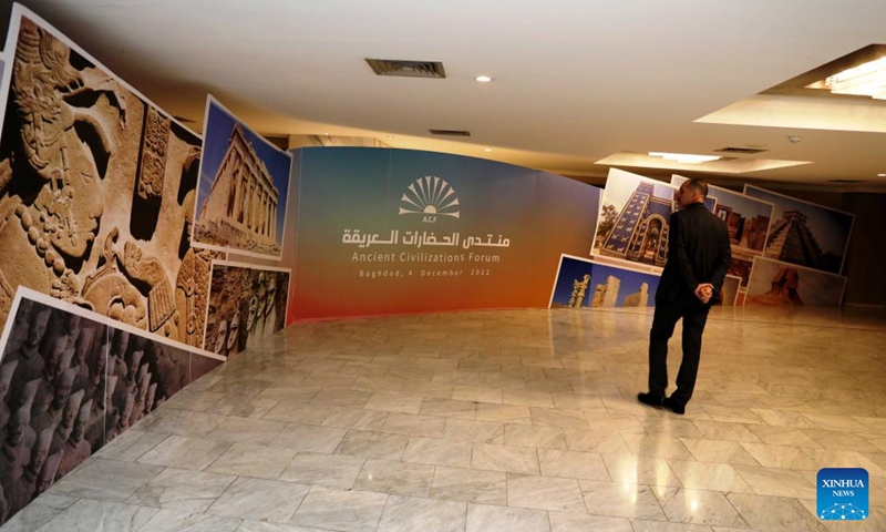 An attendee looks at images representing the civilizations of the countries participating in the Ancient Civilizations Forum in Baghdad, Iraq, on Dec. 4, 2022. The sixth edition of the Ancient Civilizations Forum kicked off in the Iraqi capital Baghdad on Sunday, as Iraq stressed the need for joint mechanisms to reduce the smuggling of cultural property. (Xinhua/Khalil Dawood)