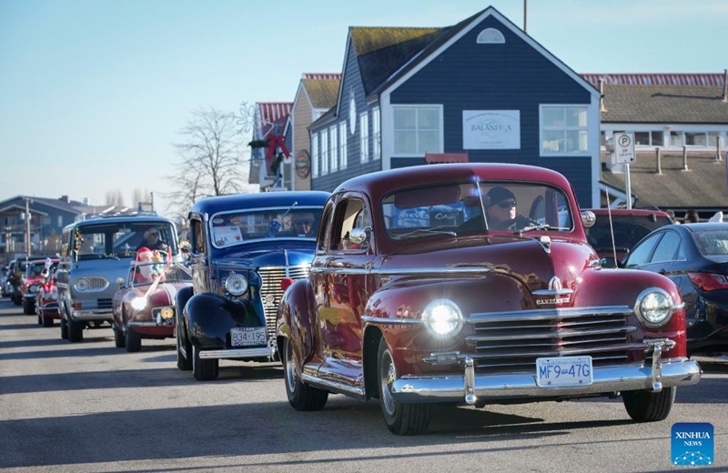 Classic cars are seen cruising on a street during the annual Christmas Classic Car Cruise event in Richmond, British Columbia, Canada, on Dec. 4, 2022. (Photo by Liang Sen/Xinhua)