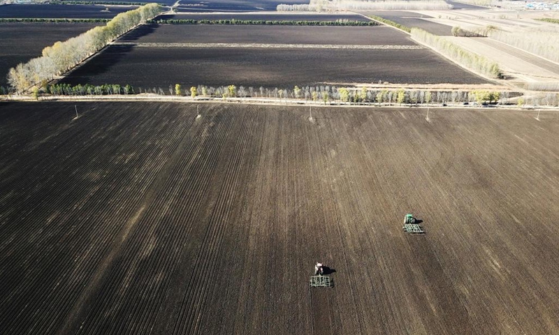 This aerial photo taken on Oct. 15, 2022 shows agricultural machines preparing the field for planting at Xinghua Township, Baiquan County, northeast China's Heilongjiang Province. Dec. 5 marks World Soil Day, a day designated by the UN to highlight the importance of healthy soils and to advocate sustainable management of soil resources.(Photo: Xinhua)