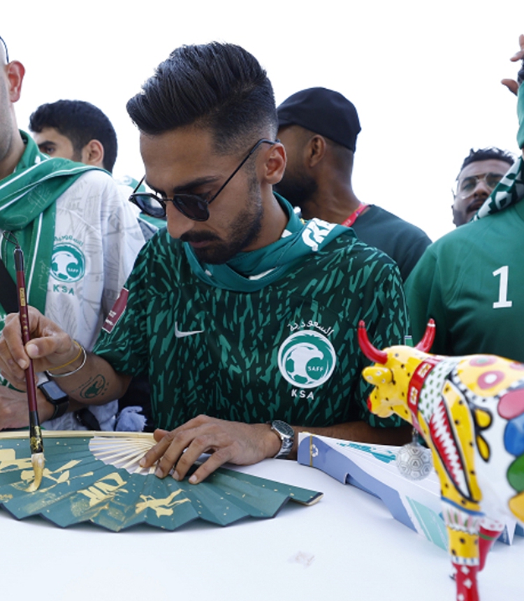 Saudi Arabian soccer fans learn to write Chinese characters at a Chinese brand stand outside Lusail Stadium in Qatar on November 22, 2022. Photo: VCG