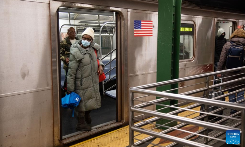 A woman wearing a face mask gets off a train at a subway station in New York, the United States, on Dec. 7, 2022. The United States is experiencing surge in respiratory illnesses including COVID-19, flu and respiratory syncytial virus (RSV), worsening the strain on hospitals.(Photo: Xinhua)