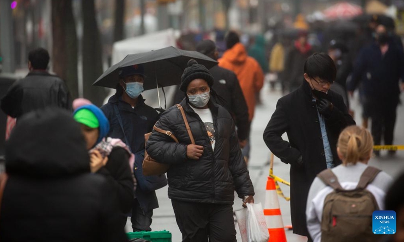 People wearing face masks walk along Fulton Street in New York, the United States, on Dec. 7, 2022. The United States is experiencing surge in respiratory illnesses including COVID-19, flu and respiratory syncytial virus (RSV), worsening the strain on hospitals.(Photo: Xinhua)