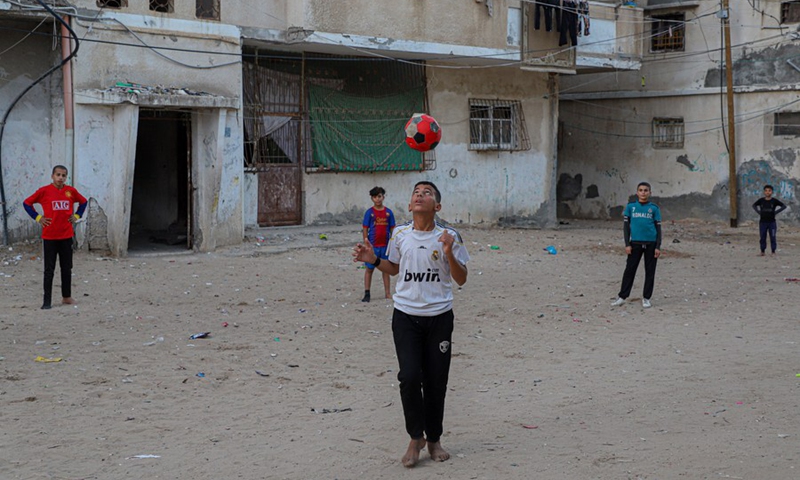 Palestinian boys play football in a street at the Shati refugee camp in Gaza City, on Nov. 30, 2022.(Photo: Xinhua)