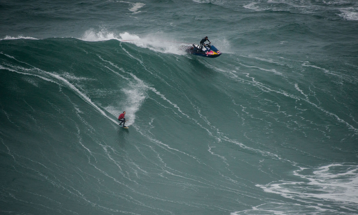 Surfers come to brave the big waves of Nazare in Portugal. Photos: AFP