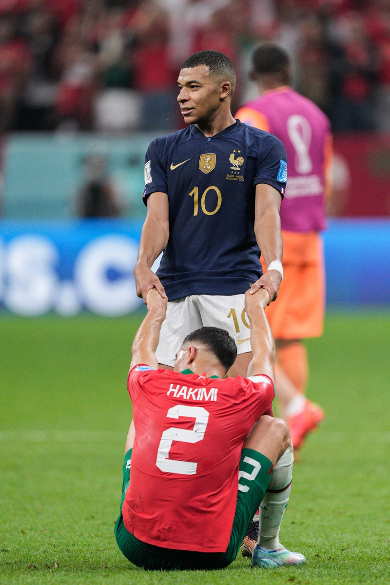Kylian Mbappe (No.10) of France consoles Morocco's Achraf Hakimi, his teammate at Paris Saint-Germain, after the World Cup semifinal match between France and Morocco at the Al Bayt Stadium in Al Khor, Qatar on December 14, 2022. Photo: IC
