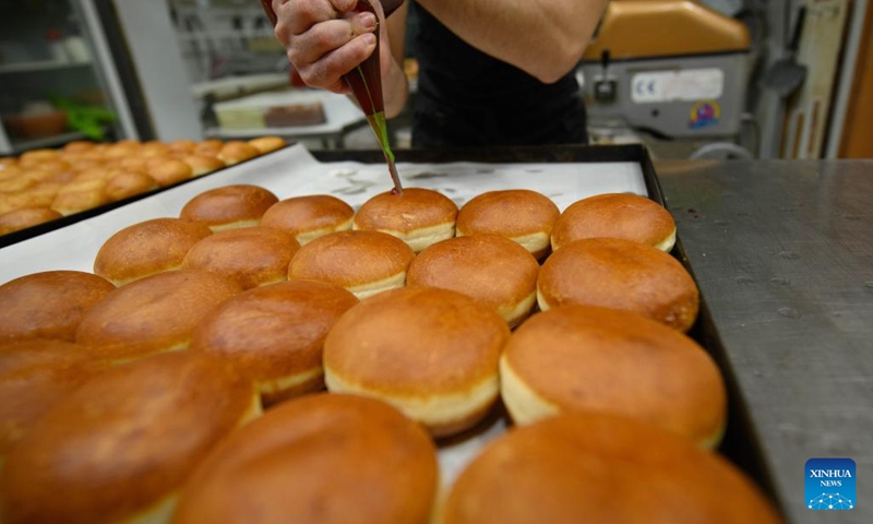 A bakery worker makes sufganiyot, round jelly donuts eaten during the Jewish festival of Hanukkah, at a bakery in Kiryat Shmona, northern Israel, on Dec. 14, 2022.(Photo: Xinhua)