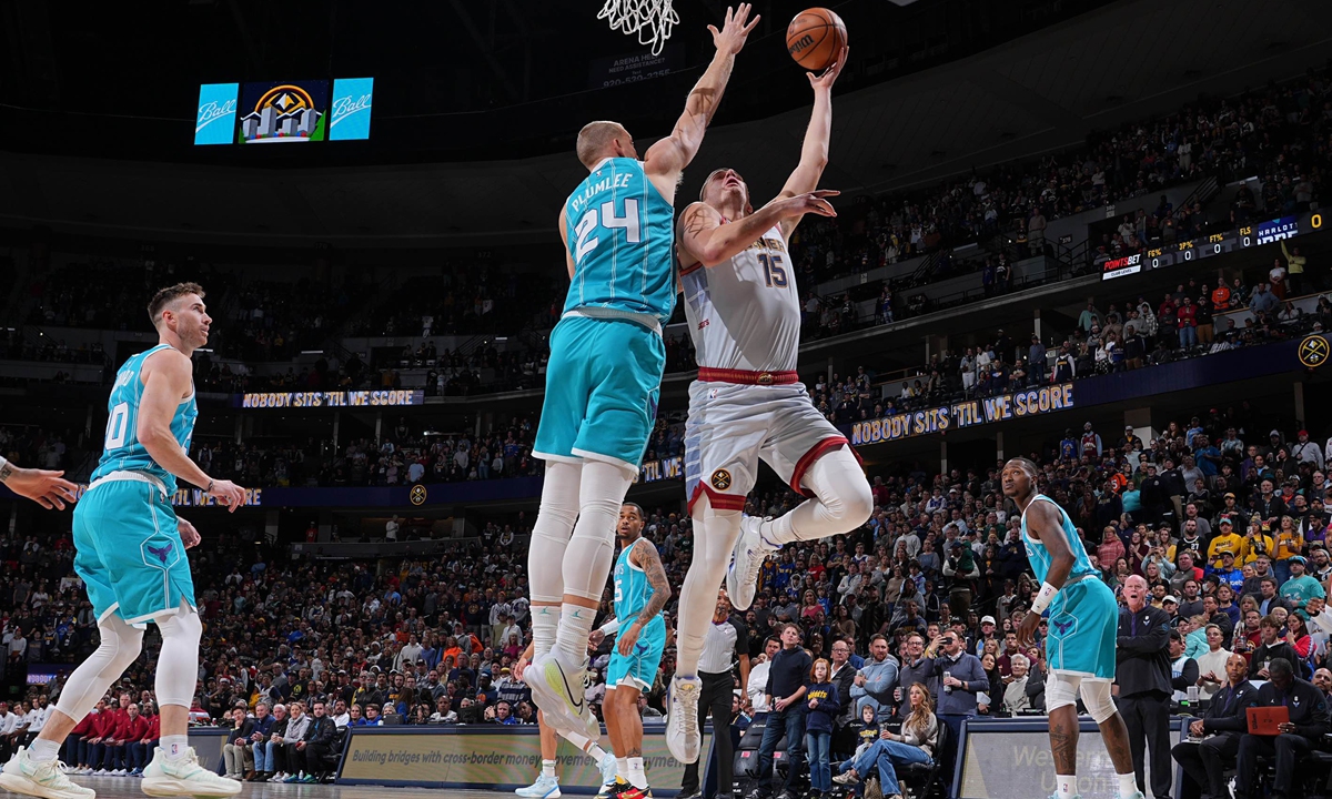 Nikola Jokic (right) of the Denver Nuggets drives to the basket against the Charlotte Hornets on December 18, 2022 in Denver, Colorado, the US. Photo: VCG