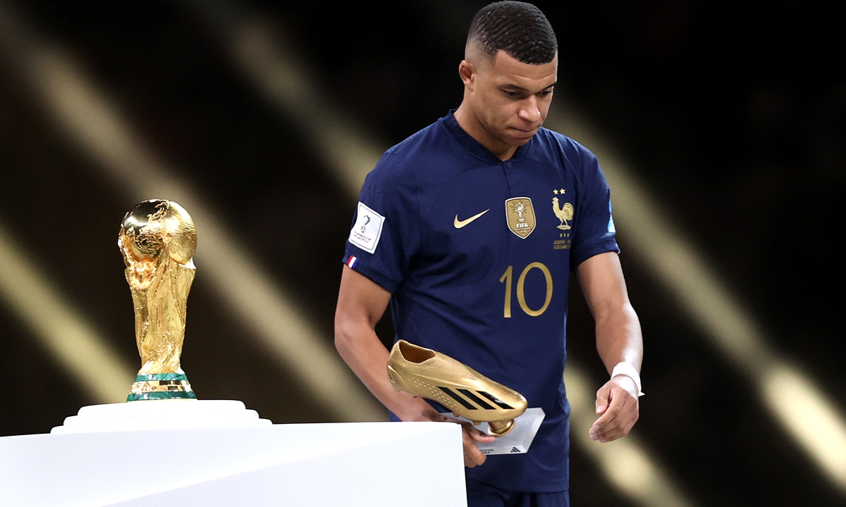 Kylian Mbappe of France looks dejected as he walks past the World Cup Trophy after the final match between Argentina and France on December 18, 2022 in Lusail City, Qatar. Photo: VCG