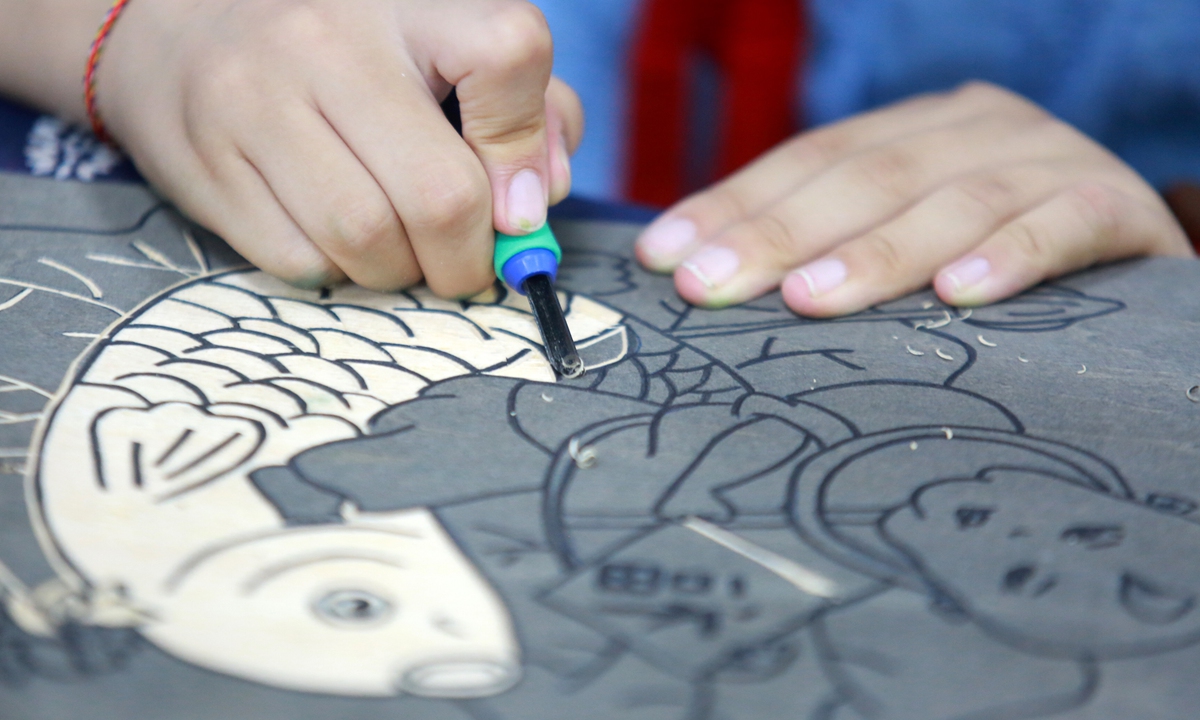 Children learn traditional woodblock printing skills in Yangzhou, Jiangsu Province. Photo: IC