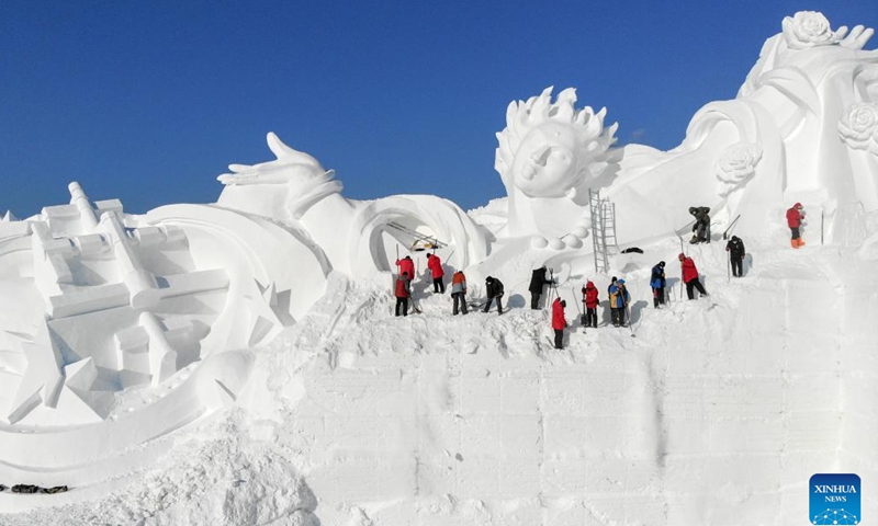 This aerial photo taken on Dec. 18, 2022 shows staff members working on a gigantic snow sculpture for the upcoming 35th Taiyangdao Island International Snow Sculpture Expo in Harbin, northeast China's Heilongjiang Province.(Photo: Xinhua)