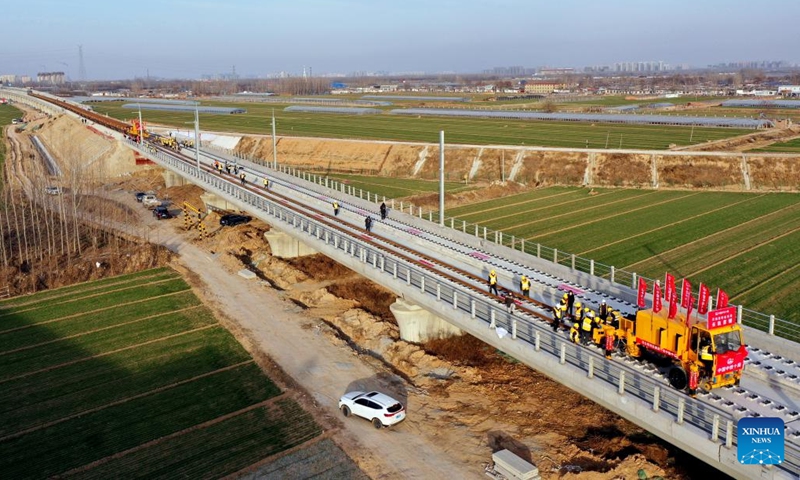 This aerial photo taken on Dec. 15, 2022 shows workers laying tracks at the construction site of the Jinan-Zhengzhou high-speed railway in Liaocheng City, east China's Shandong Province. The track-laying ceremony of the Shandong section of Jinan-Zhengzhou high-speed railway was held in Liaocheng City on Thursday.(Photo: Xinhua)