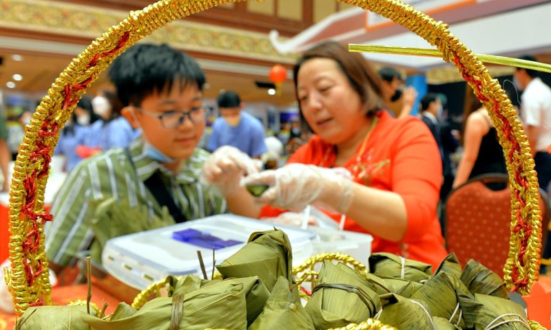 People make Zongzi, a traditional Chinese food, during a China Day cultural event in Bandar Seri Begawan, Brunei, on Dec. 16, 2022. The China Day cultural event, as part of the Brunei December Festival, was launched here at the International Convention Center on Friday. A series of activities showcasing Chinese cultures such as wushu, calligraphy, delicacy, and sales of Chinese goods and specialties will be staged during the three-day cultural event. (Photo by Jeffrey Wong/Xinhua)