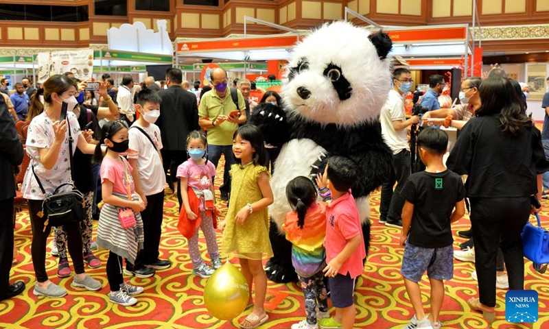 Children pose with a panda mascot during a China Day cultural event in Bandar Seri Begawan, Brunei, on Dec. 16, 2022. The China Day cultural event, as part of the Brunei December Festival, was launched here at the International Convention Center on Friday. A series of activities showcasing Chinese cultures such as wushu, calligraphy, delicacy, and sales of Chinese goods and specialties will be staged during the three-day cultural event. (Photo by Jeffrey Wong/Xinhua)