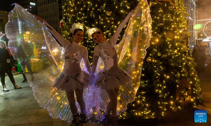 Two girls dressed as fairies pose by a Christmas tree in Athens, Greece, on Dec. 18, 2022. (Xinhua/Marios Lolos)