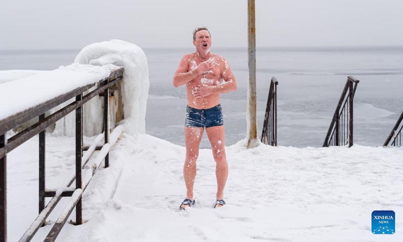 A swimmer rubs his body with snow after swimming in the icy sea of Amur Bay, Vladivostok, Russia, Dec. 21, 2022.(Photo: Xinhua)