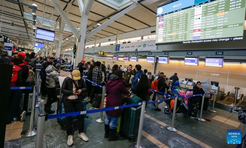 Passengers wait in a check-in line at Vancouver International Airport in Richmond, British Columbia, Canada, on Dec. 20, 2022. Thousands of travelers were stuck at the Vancouver International Airport on Tuesday as many flights were cancelled or delayed due to the snowstorm.(Photo: Xinhua)