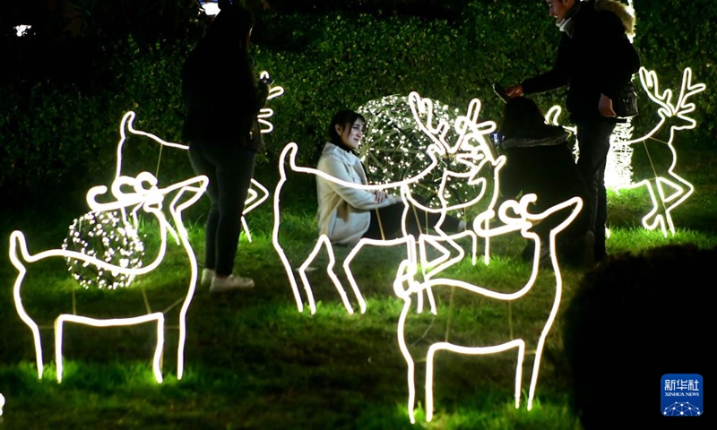 A woman poses for photos among Christmas decorations in Damascus, Syria, on Dec. 22, 2022.(Photo: Xinhua)