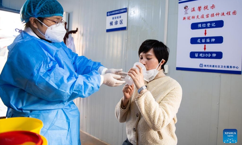 A resident (R) receives a dose of inhalable COVID-19 vaccine at a community health service center in Tianxin District of Changsha, central China's Hunan Province, Dec. 22, 2022. Inhalable COVID-19 vaccines are available at many vaccine sites in Changsha now as the epidemic continues to rage. China has approved the inhalable vaccine for emergency use among populations aged 18 and above who had received two doses of traditional vaccines, but not within the previous six months.(Photo: Xinhua)