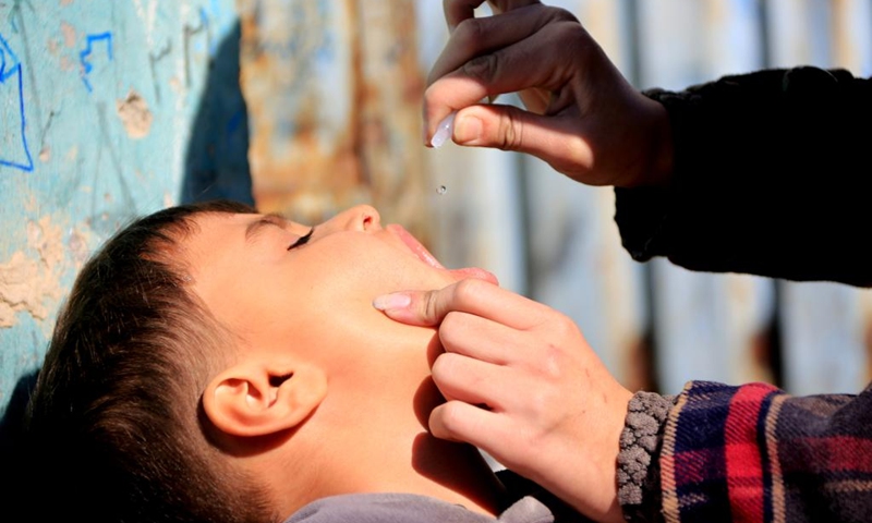 A health worker gives a dose of the polio vaccine to a child during a vaccination campaign against polio in Kabul, Afghanistan, Dec. 21, 2022. Afghanistan's Ministry of Public Health has launched a campaign to vaccinate around 7 million children under five against polio, said a statement released by the ministry on Tuesday.(Photo: Xinhua)